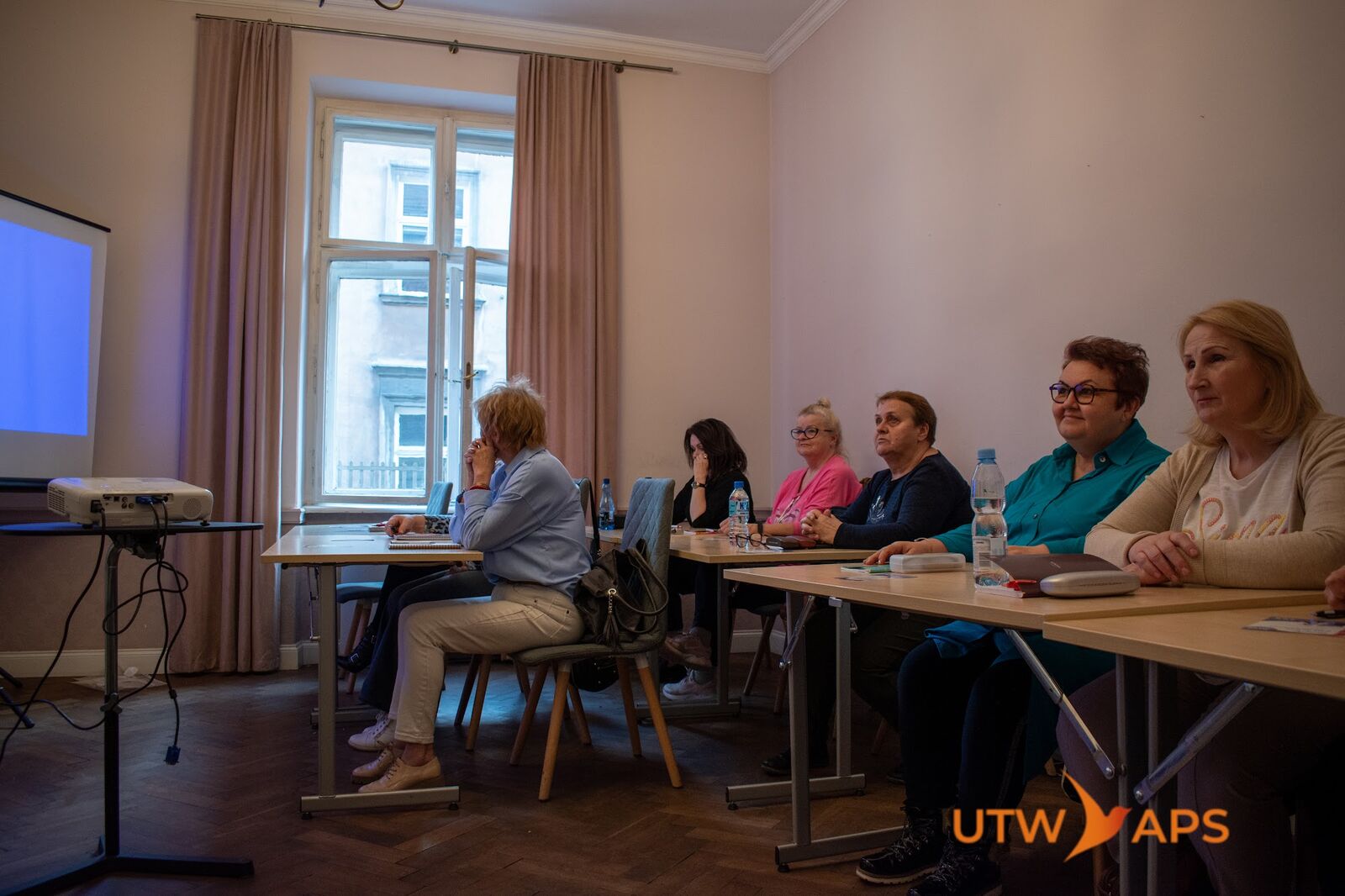 Sala zajęciowa z projektorem i kursantami podczas lekcji językowej w Krakowie