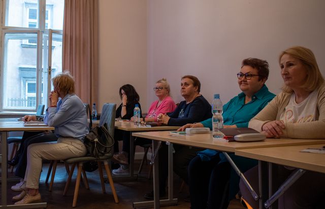 Grupa kursantów słucha lektora na zajęciach w Krakowie