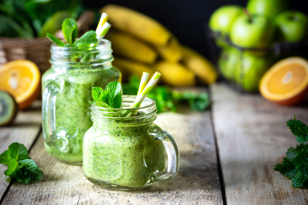 dwa zdrowe zielone koktajle ze szpinakiem bananem jablkiem kiwi i mieta w szklanym sloju i skladnikach dieta detox koncepcja zdrowej wegetarianskiej zywnosci - Uniwersytet Trzeciego Wieku Online